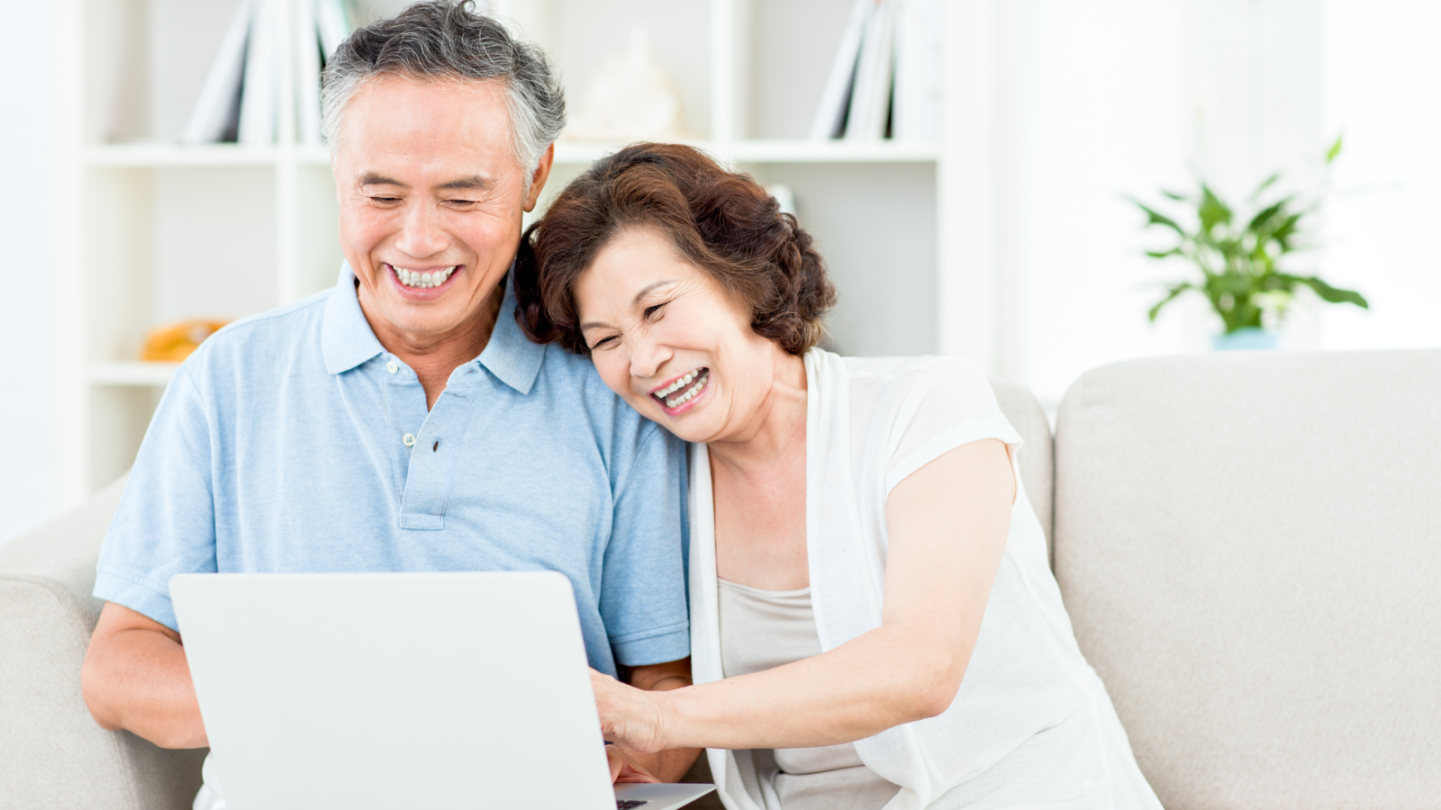 Couple smiling and looking at a laptop